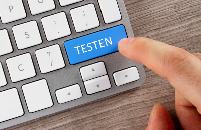 Finger drückt auf eine Taste mit der Aufschrift Testen
